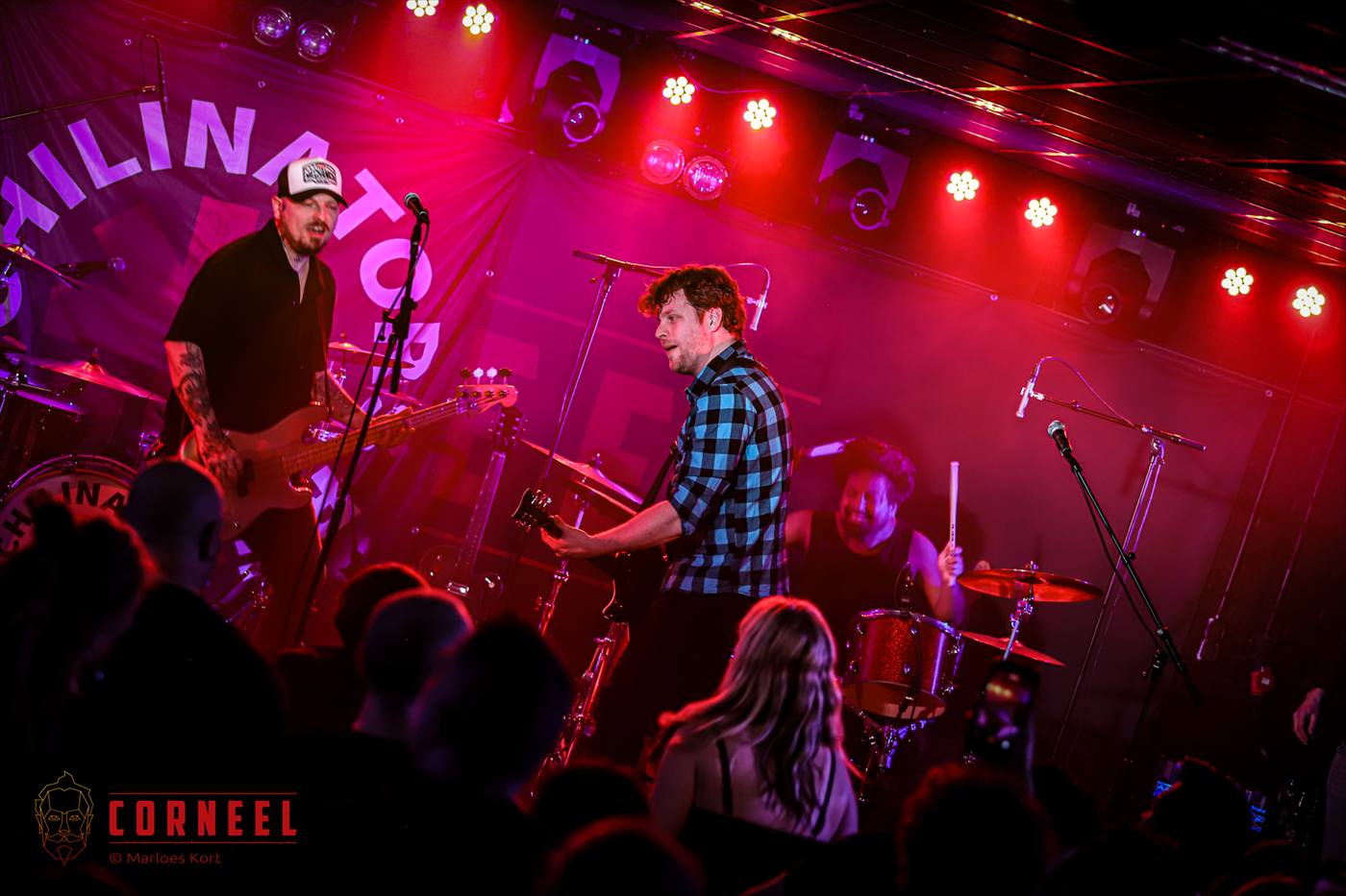 Villains live met publiek, drumkit en rode podiumlichten